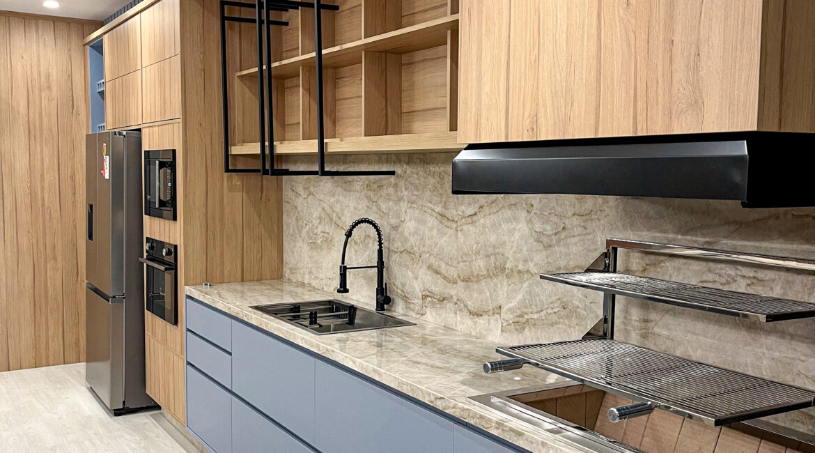 Cozinha planejada azul com amadeirado da linha Scavatta, com bancada em mármore e design moderno